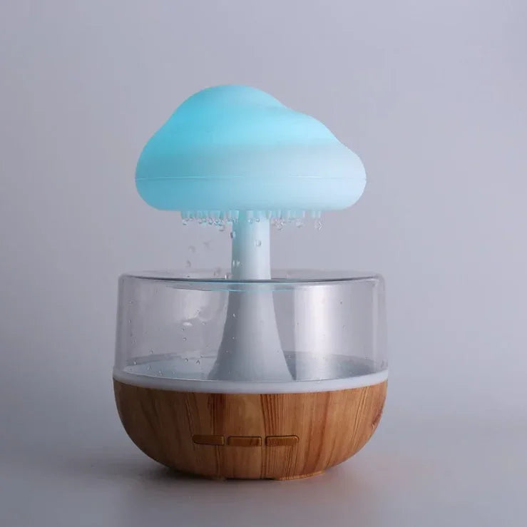 Cloud-shaped LED humidifier with wooden base and clear water tank on light background