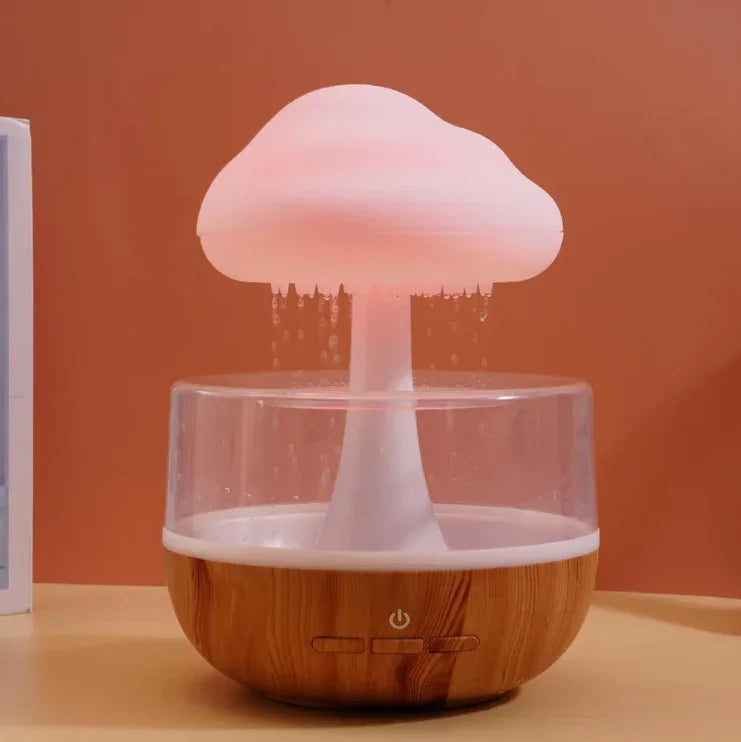 Cloud-shaped LED humidifier with wood base on a beige table, water mist flowing down